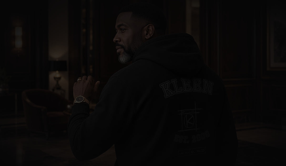 Mr. Kleen in the Blackout varsity hoodie in a dim hotel lobby. Kleen Klothing Co. First Run, coming November 27.